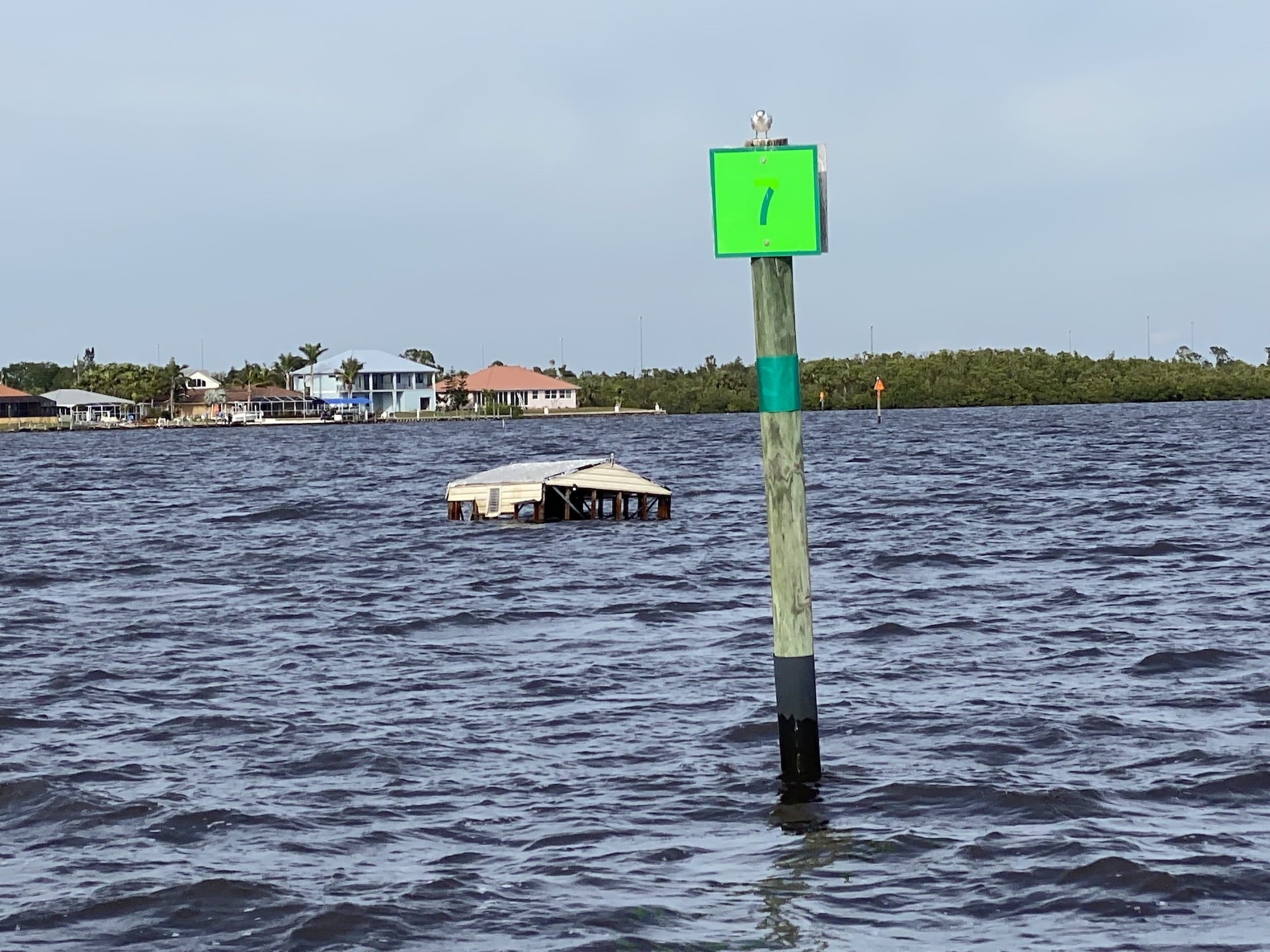 Green marker and debris in the water near Ft. Myers after Hurricane Ian.