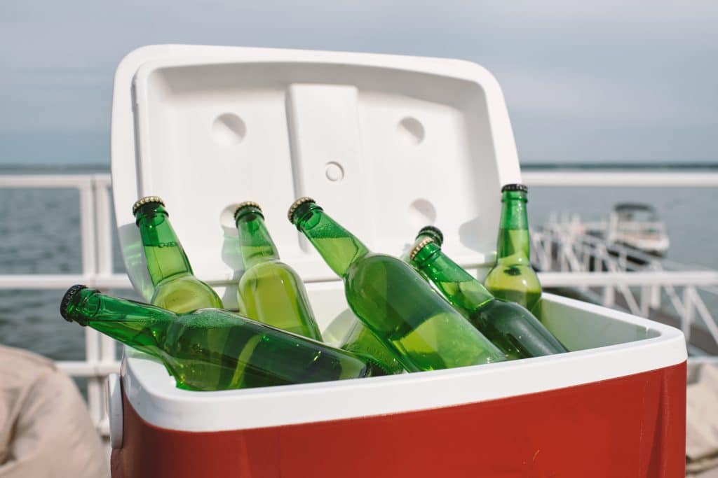 red cooler filled with green bottles