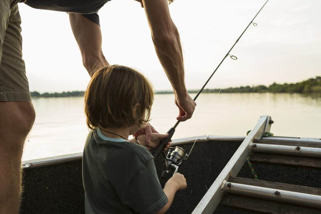 father teaching son to fish